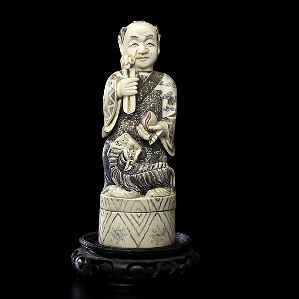 Japanese Ivory Figural Box : Japanese Ivory Figural Box Japanese, 20th century. A carved and polychrome figural box, the top having a seated man, with kinetic head, holding a scepter and peach, with a foo dog by his side