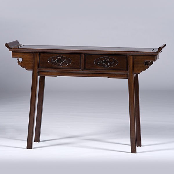 Chinese Carved Altar Table : Chinese Carved Altar Table Chinese, 20th century. A mahogany carved altar table of long narrow form with scrolling flange ends and square legs; ht. 33, wd. 41, dp. 14 in. Provenance: Ex Collection