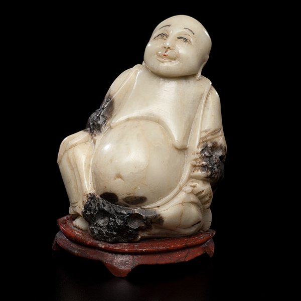 Chinese Soapstone Buddha : Chinese Soapstone Buddha Chinese, 20th century. A carved soapstone Buddha with green and brown highlights, having a painted face and seated on a soapstone stand, unmarked; ht. 3.5 in.