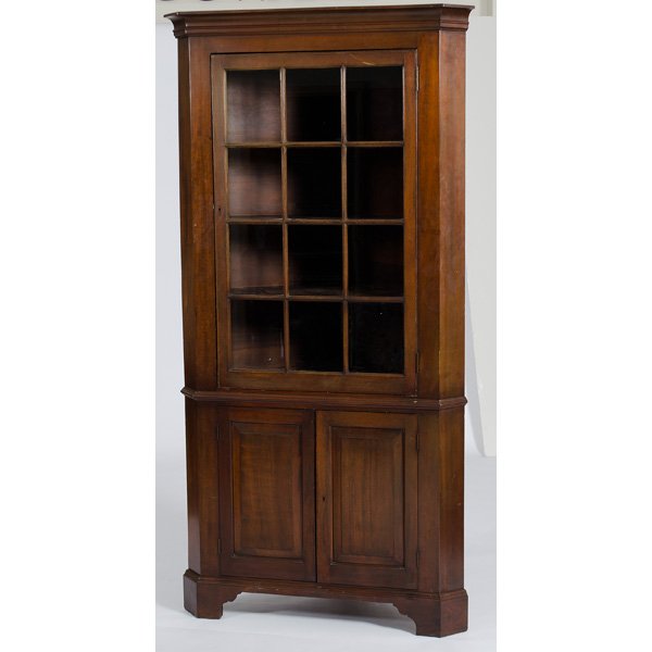 Walnut Corner Cupboard : American, 19th century, a corner cupboard in walnut having a molded cornice over a twelve-lite glazed door, shaped shelves, over two raised panel doors, resting on bracket feet; ht. 83.5, wd. 40 in.�