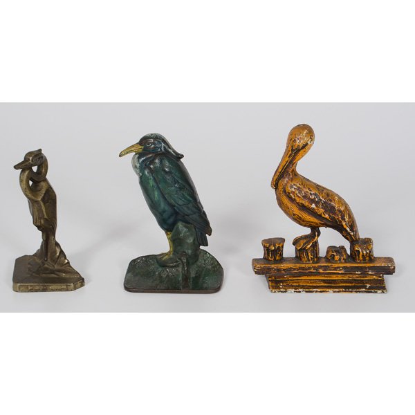 Shore Birds Cast Iron And Bronze Doorstops : American, a cast iron Pelican on dock, marked 113 Albany Fdy Co; ht. 8, lg. 7.25 in; Plus a Heron art deco with bronze plated cast iron doorstop or bookend, ht. 6.75 in; Plus a Cast iron painted Heron