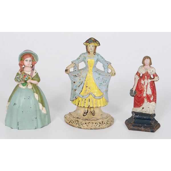 Victorian Women Doorstop : American, a cast iron and painted Victorian lady doorstop, marked Albany FDY Co.; ht. 6 in, Plus a leaded white metal painted Victorian lady doorstop, with trademark for Stirrup N.Y., Copyrig