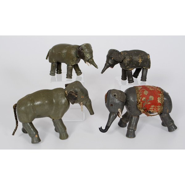 Schoenhut Wooden Circus Elephants : German, Four carved and painted Schoenhut circus elephants, one with glass eyes; largest ht.. 7 in.; Including four barrels and accessories.
