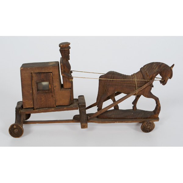 Amish Buggy Folk Art Carving : American, 20th century. A pine hand-carved folk art horse and Amish buggy with hinged door and passenger inside; ht. 7.5 , wd. 2.5, lg. 13 in.