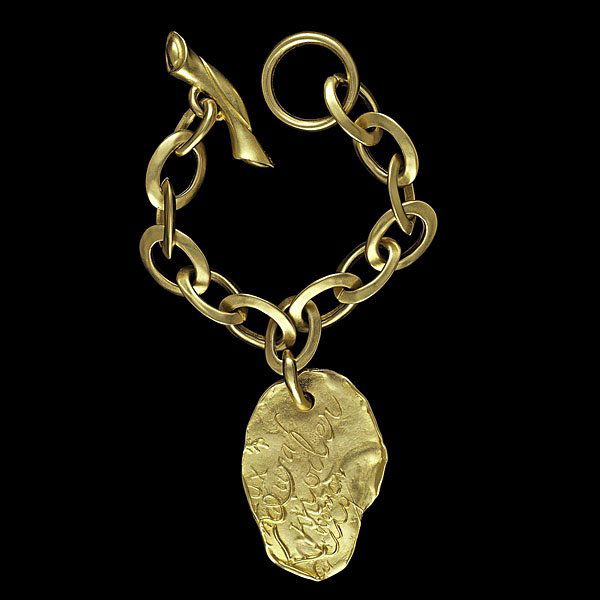 DKNY Hammered Metal Charm Bracelet : DKNY, 1980s, a heavy hammered gilt metal charm bracelet with large toggle clasp and stamped charm; bracelet lg. 7.5 in., charm lg. 2.5 in. Provenance: Property from the Collections of Carole Tanenba