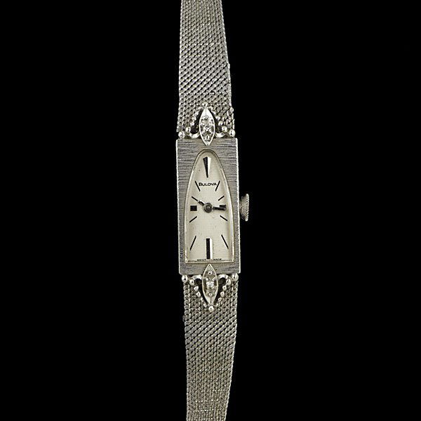 14k Vintage Lady's Bulova Watch : Vintage 14k white gold Bulova watch in a petite design accented by two diamonds, with later 10k gold filled band; lg. 7.5 in.