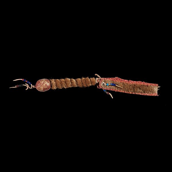 Crow Hide and Otter Fur Rattle : sinew-sewn hide rattle coated with red pigment; wooden handle wrapped with otter fur; fur wrist strap decorated with large glass beads, total length 17 in.; length of rattle 9.5 in. late 19th century�