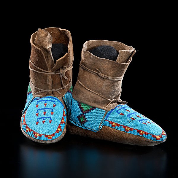 Assiniboine Beaded Hightop Moccasins : thread-sewn smoke-tanned elk or moose hide; beaded using light blue, greasy yellow, pea green, red white-heart, and dark blue, length 10 in. ca 1900