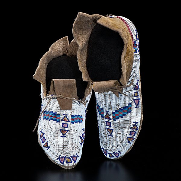 Cheyenne Beaded Hide Moccasins : sinew-sewn on thick, possibly buffalo, hide; beadwork executed in colors of white, red white-heart, greasy yellow, pink, and light and dark blue; yellow pigment on hide, length 9.25 in. late 19th cent