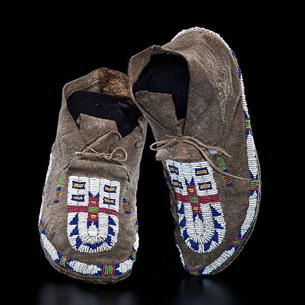 Crow Beaded Buffalo Hide Moccasins : sinew-sewn and beaded using colors of red white-heart, white, dark blue, pea green, greasy yellow, and amber, length 10 in. ca 1870