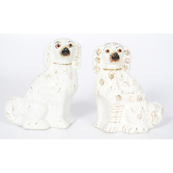 Staffordshire Spaniels with Glass Eyes, : English, late 19th century. A facing pair of large white seated "comforter" spaniels with molded fur, collars, lockets and chains and amber glass eyes; with hand painted gilding and details; ht. 11, w
