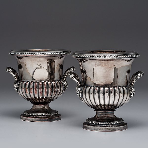 Pair of George III Sheffield Plate Two-Handled Wi : English, 19th century. A pair of Sheffield plate weighted wine coolers, each two-handled campagna-form with gadrooned bottom, reeded loop handles, springing from grape clusters and a stepped circular 