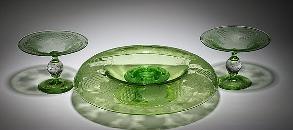 Pairpoint Glass Centerpiece and Compotes, Plus : Pairpoint Glass Centerpiece and Compotes, Plus American, 20th century. A green glass centerpiece etched with grape bunches and vines, and two glass compotes, each having a shallow bowl with engraved