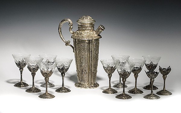 German Silver Martini Pitcher with 12 Etched Cockta: German Silver Martini Pitcher with 12 Etched Cocktail Glasses German, 20th Century. A silver martini pitcher with elaborate floral, mythological and classical motifs and 12 cocktail glasses h