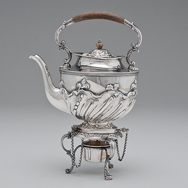 English Sterling Tea Kettle-on-Stand : English Sterling Tea Kettle-on-Stand English, ca 1890. A sterling silver tea kettle-on-stand with wooden handle and finial, with floral and shell motifs, on a stand with scrolling legs, the kettle a