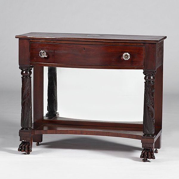 Late Classical Console Table : Late Classical Console Table American, 19th century. A mahogany console table with single long drawer above a mirrored back with leaves and feather carvings on Ionic columns flanking an inverte