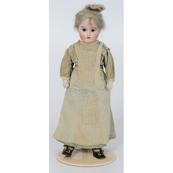 German Bisque Doll : German Bisque Doll German. A bisque porcelain doll, with brown glass eyes, painted face, grey hair, and plaster cast hands. Doll is attired in green gingham dress and black shoes; ht. 14, wd. 4.5