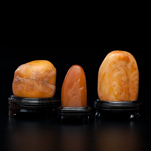 Chinese Carved Soapstone Seals : Chinese Carved Soapstone Seals 20th century. Three (3) soapstone seals of amber tone, on stands, each boulder form carved in low relief with landscapes and scholarly pursuits; tallest with stand 