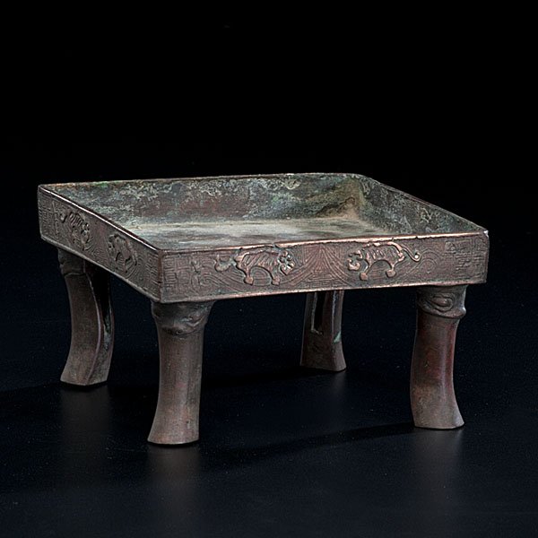 Japanese Bronze Footed Stand : Japanese Bronze Footed Stand Late 19th century or early 20th. An archaic style bronze tray, with rim having animal motif and Shang style scrollwork, intended as a stand; ht. 3 in. Ex Collection of 
