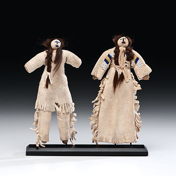 Plains Hide Dolls : Plains Hide Dolls pair of dolls with cloth bodies and dressed in hide clothing; beaded facial features and human hair, heights 7 in. and 7.25 in. early 20th century