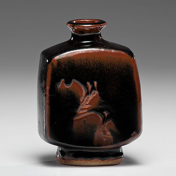 Bernard Leach (1887-1979; Hong Kong/UK) : Square Bottle ca 1945 Stoneware: ht 7.5, wd 5, dp 3 inches; artist impressed seal on foot. This handsome press molded bottle features Leach’s elegant relief drawing. Tenmoku iron glaze “brea