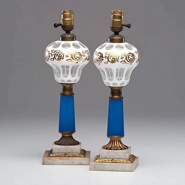 Pair Sandwich Cut Overlay Glass Lamps : American, second half of 19th century. Pair of cut overlay glass stand lamps, having cut alabaster white to clear glass pyriform fonts with gilt border pattern, supported by blue glass shafts on g