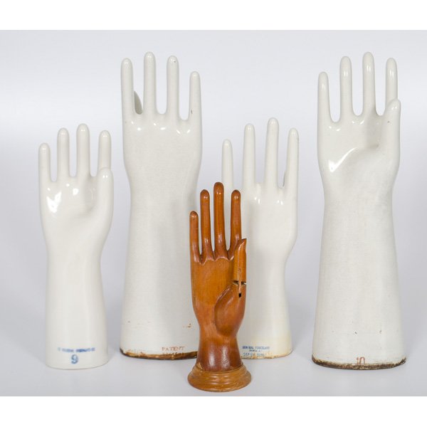 Porcelain and Wood Glove Forms : Group of four white porcelain coated glove forms, including two pairs of varying size, as well as a carved wood form with opposable thumb; tallest ht. 17.5 in.
