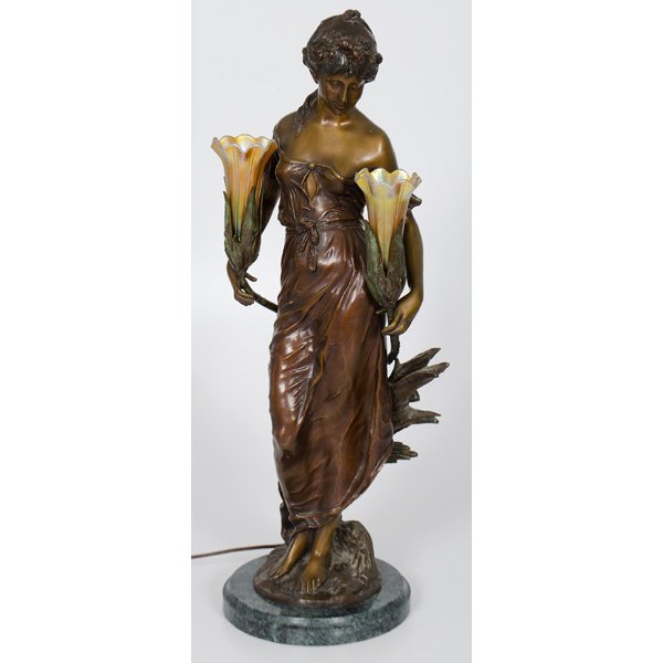 Bronze Figural Newel Post Lamp : 20th century. A reproduction bronze figural newel post lamp, after Moreau, with favrille shades mounted on a circular green marble base; ht. 29 in.