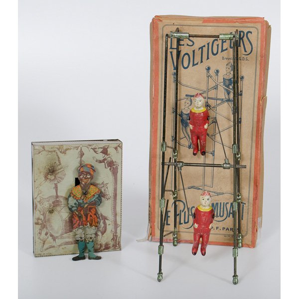 American and French Tin Toys : 20th century. Two metal toys, including black Americana jigging toy and French plaster and metal "Les Voltigeurs" gravity driven toy by Les Plus Amusant of Paris, accompanied by original box; dancing