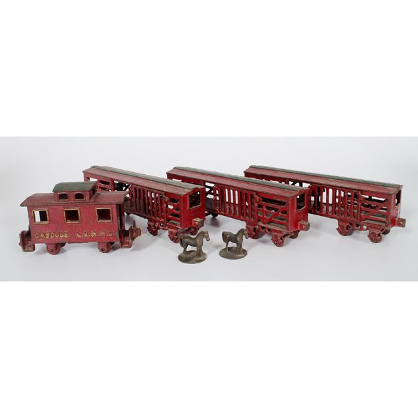 Cast Iron Train Cars : Late 19th-early 20th century. Four red and green painted train cars, including three freight train cars with sliding doors, one caboose, and five cast iron horses on stands for use in the freight con