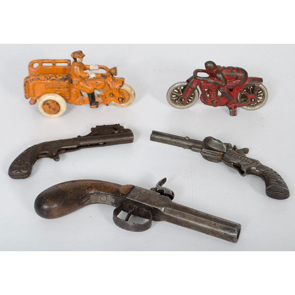 Cast Iron Toy Pistols and Motorcycles : American, late 19th-early 20th century. Three toy pistols and two cast iron motorcycles, including one Kenton cap gun with cannon form mechanism, an Ives "Lion" cap gun with 1890 patent date, and an