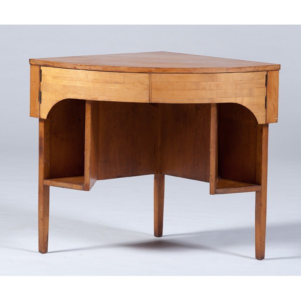 Mid-Century Corner Table : American, 20th century. A mid-century corner table in maple, having three sides, the front with hinged panels that open to reveal a drawer, over two side shelves, all on three tapered legs; ht. 30, wd