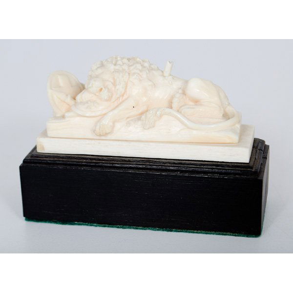 Carved Ivory of the Lion of Lucerne : Continental. A carved ivory lion on a pedestal after the Swiss sculpture Lion of Lucerne by Bertel Thorvaldsen, depicting a mortally wounded lion, lying in a protective embrace of a shield emblazoned