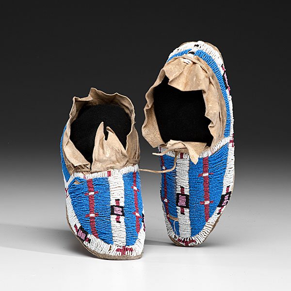 Central Plains Beaded Hide Moccasins : thread-sewn on softly tanned hide and beaded using colors of medium blue, red white-heart, black, pink, and white; forked tongue and slightly split cuff, length 10.25 in. ca 1900