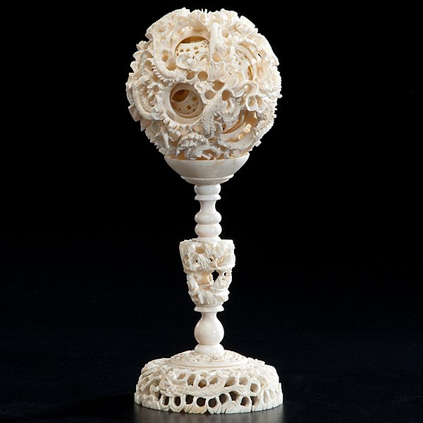 Chinese Ivory Puzzle Ball on Stand : Chinese, early 20th century. An ivory puzzle ball on ivory stand, with reticulated carving of dragons and floral scrolling. Diameter of ball 3.25 in., overall ht. 8.25 in.