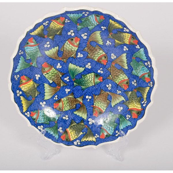 Faience Fish Plate : Faience Fish Plate Continental, 20th century. A ceramic plate decorated with fish in shades of light blue and green, all set against a blue background with white accents resembling waves, having a m