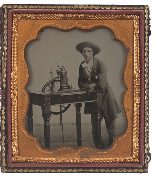 Occupational Sixth Plate Ambrotype of a Man with a: Occupational Sixth Plate Ambrotype of a Man with a Steam Piano Sixth plate ambrotype of a young man posed with a steam piano. Housed in a pressed paper case, separated at the spine. Provenance: 