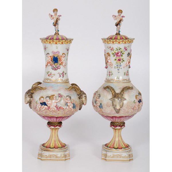 Large Capodimonte Polychrome Urns : Large Capodimonte Polychrome Urns Continental. A pair of large Capodimonte porcelain lidded urns, with polychrome decorations and gilt highlights, each having a lid with putti finials, ram's head ha
