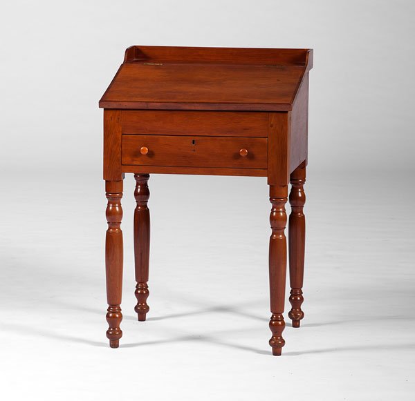 School Teacher's Desk in Cherry : School Teacher's Desk in Cherry American, 19th century. A school teacher's desk in cherry, the rectangular top with gallery and having a hinged slant-lid concealing a deep well with fitted interior,
