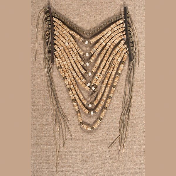 Crow Bone Loop Necklace : Crow Bone Loop Necklace ten hide thongs strung with bone disks and brass beds; hide strands lace through harness leather strips and finish as fringe, overall length 13 in. x width 8 in.; mounted 16.