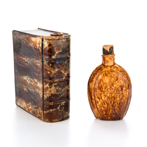 Yellow Ware Flasks : Yellow Ware Flasks American, 19th century. Two yellow ware flasks in including a flint glazed book flask and pocket flask with cork, with embossed decoration of a chalice and cornucopia; book ht. 6.