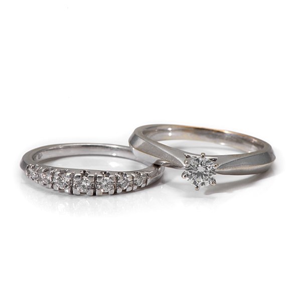 A 14 Karat White Gold Diamond Wedding Set : A 14k white gold knife-edge solitaire and wedding band containing one VS1, F-G color center diamond weighing approximately .25 carats. The wedding band contains 7 VS2, G color round diamonds weighing 