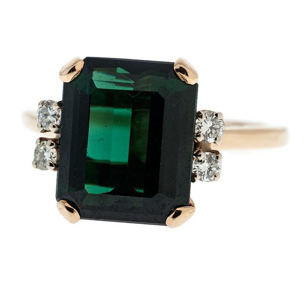 A 14 Karat Yellow Gold Green Tourmaline and Diamond: A 14k yellow gold ring featuring a 10.7mm x 8.8mm x 5.15mm emerald cut green tourmaline center stone accompanied by 4 VS2, H-I color round brilliant diamonds weighing approximately .10 carats total we