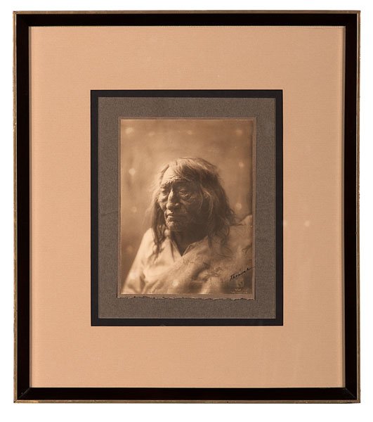 Richard Throssel Signed Photograph, The Old Historyain : Sepia toned platinum photograph of an aged, Crow Indian identified as The Old Historyain, with copyright, blindstamped arrowhead, and Richard Throssel's signature at lower right, affixed to ori