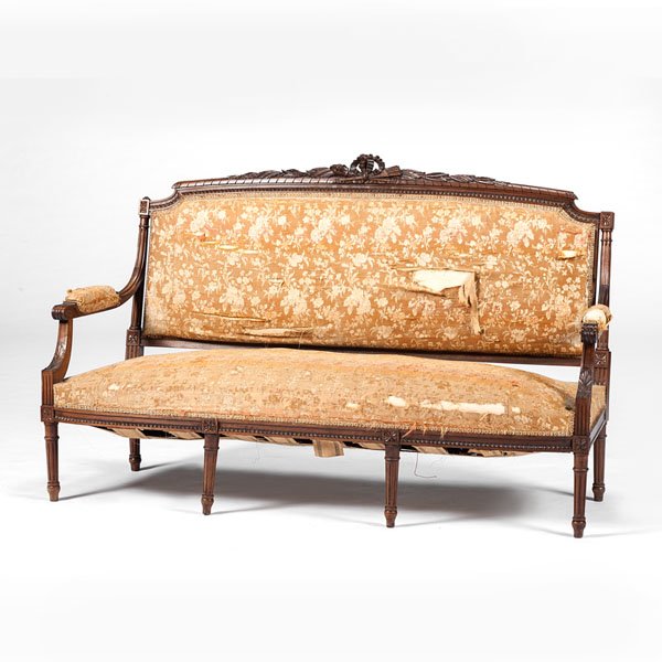 Louis XVI-Style Settee : Louis XVI-Style Settee French, 19th century. A Louis XVI-style upholstered settee having an elaborately carved crest featuring acanthus leaves, a torch and a quiver, fluted arms and back rails with 