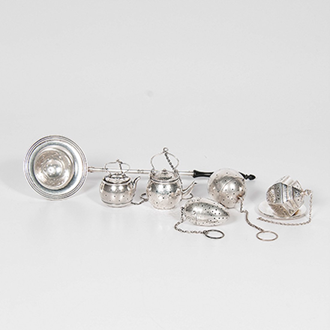 Sterling Tea Balls, Plus : Sterling Tea Balls, Plus American, 20th century. A group of five tea balls with one resting dish including two shaped like teapots, one with J.F. Fradley & Co. hallmark, one with Webster Company