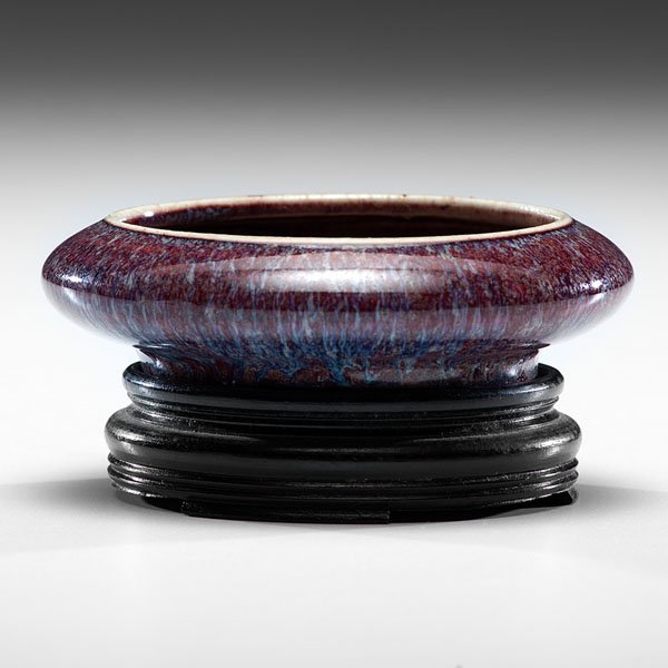 Transmutation Glaze Brush Washer : Transmutation Glaze Brush Washer Chinese, Qing dynasty, Guangxu period. A round brush water with a dark purple glaze with blue streaks, resting on a custom wooden stand. Dia. 4.5 in.