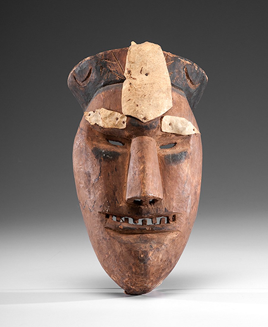 Cherokee Carved Booger Mask : Cherokee Carved Booger Mask carved with an elongated face, narrow nose, and toothy grin; hide remnants are nailed to brow and forehead; mask is further embellished with a crown carved with crescent