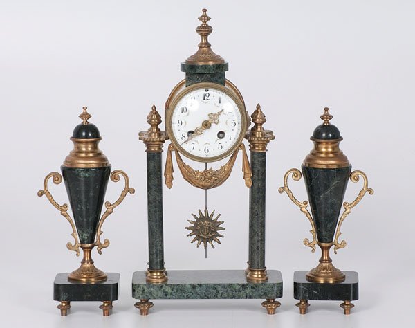 French Clock Garniture : French Clock Garniture French, 19th century. A three-piece marble and gilt metal clock garniture, the four column portico clock having an enamel dial with polychrome floral swags and ormolu mounts,