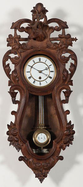 German Black Forest-Style Wall Clock : German Black Forest-Style Wall Clock German, late 19th century. An eight-day, spring-driven timepiece in the Black Forest-style with overall carving and surmounted by a stag's head, with original R